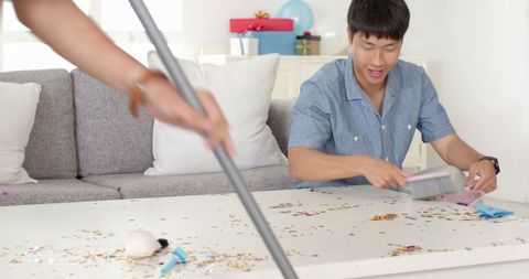Couple Cleaning Colorful Confetti from Home Celebration