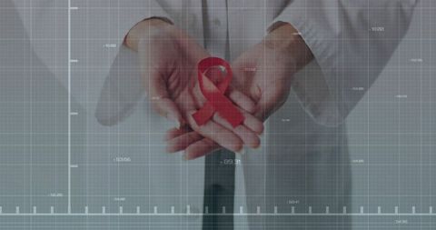 Doctor presenting red awareness ribbon in technological grid background