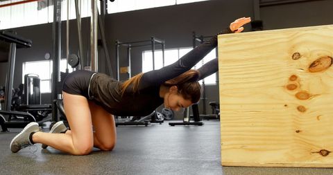 Focused Woman Stretching in Modern Fitness Gym