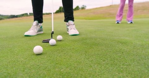 Golf Partners Aligning Putts on Vibrant Green Course