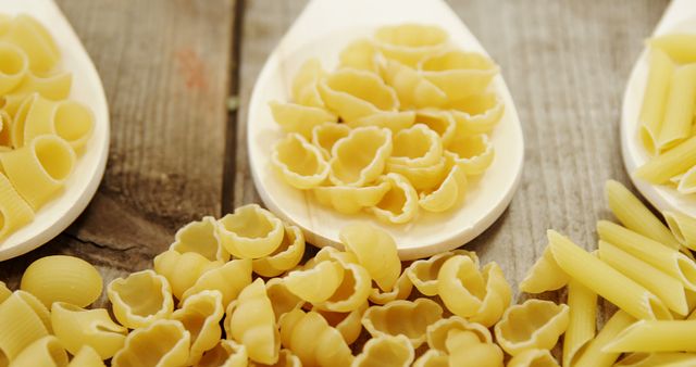 Assorted Uncooked Pasta Displayed on Wooden Table - Download Free Stock Images Pikwizard.com