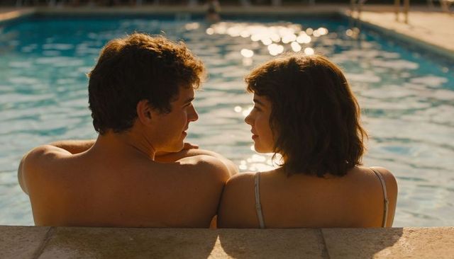 Young couple relaxing at pool edge sharing intimate conversation during sunlit golden hour