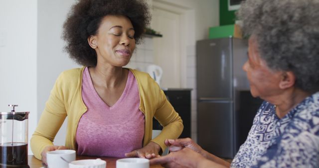 Happy african american adult daughter and senior mother drinking coffee, slow motion - Download Free Stock Photos Pikwizard.com