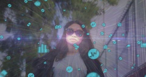Woman wearing sunglasses walking through augmented reality data icons with lensflare