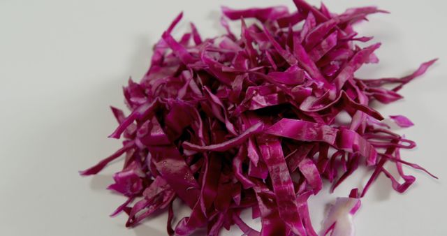 Close up of cut in stripes fresh red cabbage on white background. Health, diet and food.