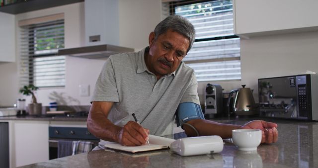 Senior Man Noting Blood Pressure Measurements in Modern Kitchen - Download Free Stock Images Pikwizard.com