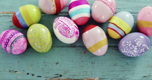 Colorful Easter eggs with intricate patterns are displayed on a rustic wooden surface, with copy space. These eggs symbolize the celebration of Easter and the tradition of egg decoration.