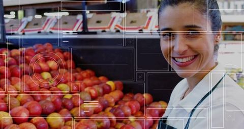 Smiling employee organizing red apples at store display