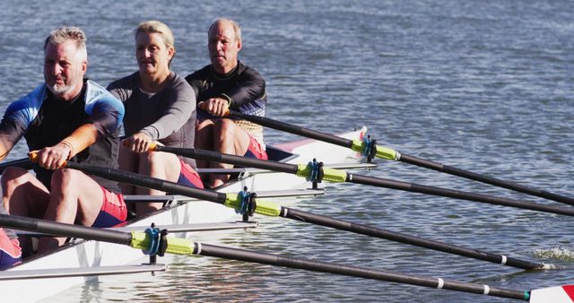 Four senior caucasian men and women rowing boat on a river. sport retirement leisure hobbies rowing healthy outdoor lifestyle.