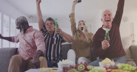 Diverse Friends Celebrating Victory on Home Sofa - Download Free Stock Images Pikwizard.com