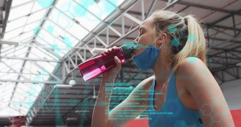 Woman in Gym Drinking Water with Data Overlay