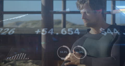 Surfer Analyzing Digital Data Interface on Beach