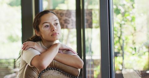 Thoughtful Biracial Woman with Vitiligo Relaxing at Window