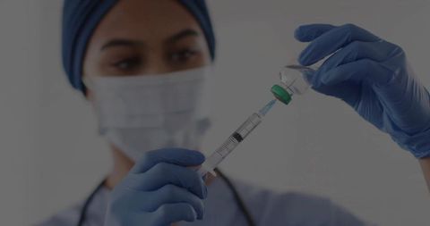 Nurse Preparing Vaccine with Syringe in Clinical Environment