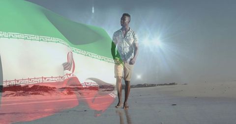 Man walking on wet beach with iranian flag overlay, sun glare and coastal reflection