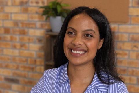 Smiling Woman in Striped Shirt Relaxing in Stylish Lounge