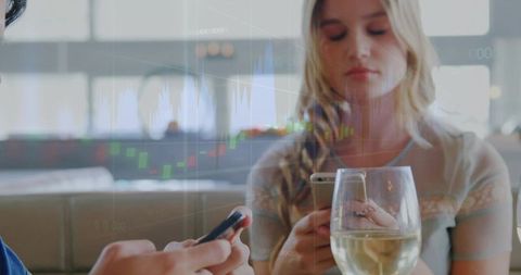 Young woman checking phone at cafe with wine and stock market chart overlay