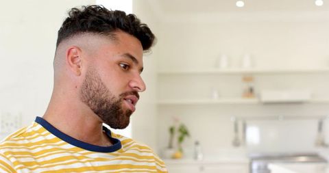 Man in Minimalist Kitchen Observing Quiet Beverage Moment