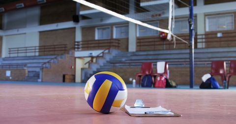 Volleyball and Clipboard on Gym Floor in Empty Sports Hall