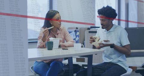 Colleagues sharing lunch in modern office breakroom for casual team collaboration
