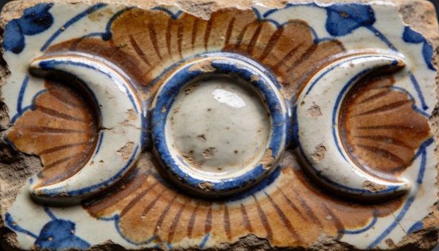Antique glazed ceramic tile fragment featuring raised triple-moon crescent and sunburst