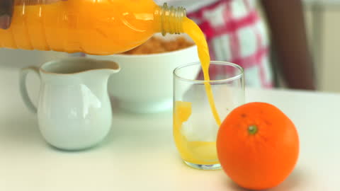 Pouring Fresh Orange Juice into Glass for Morning Breakfast in Slow Motion