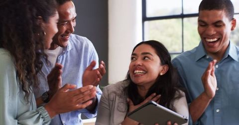 Diverse Team Celebrating Success with Tablet in Office