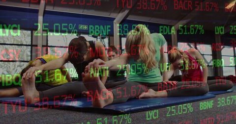 Women stretching in yoga class with financial ticker overlay