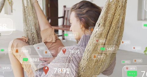 Woman reading book at home amid digital notifications display