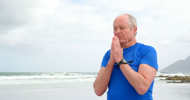 Senior Man Meditating on Beach in Blue Shirt - Download Free Stock Images Pikwizard.com