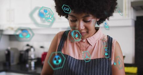 Young woman monitoring smart kitchen energy with holographic eco icons and appliance data