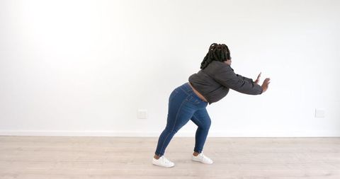 Woman Dancing Joyfully in Minimalist Room