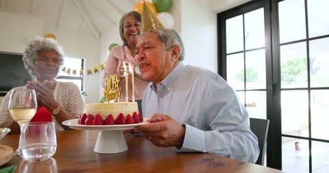 Happy Senior Celebrating Birthday with Friends in Cozy Home