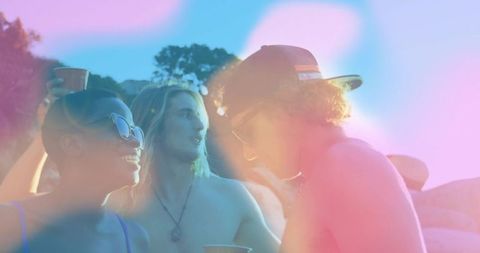 Joyful friends enjoying sunset together outdoors