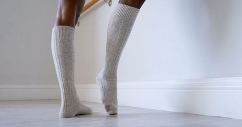 Woman exercising with barre wearing long gray socks