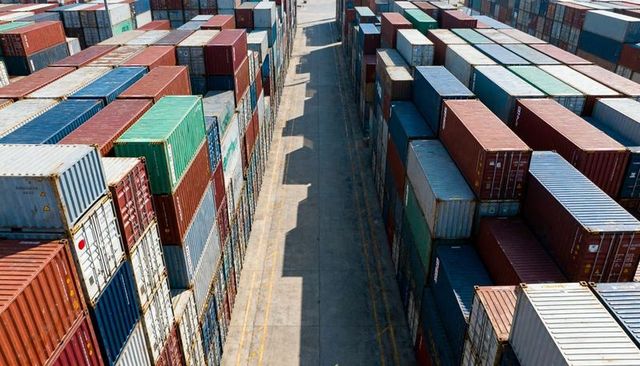 Aerial perspective showing stacked shipping containers forming parallel rows at port terminal