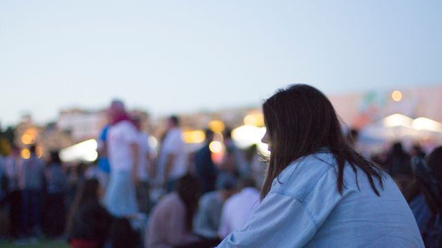 Woman in Casual Outfit Sitting Outdoors at Festival during Evening - Download Free Stock Images Pikwizard.com