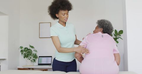 African American Therapist Assisting Senior Woman with Recovery Exercises