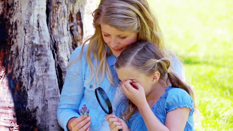 Mother and Daughter Exploring Nature Together with Magnifying Glass