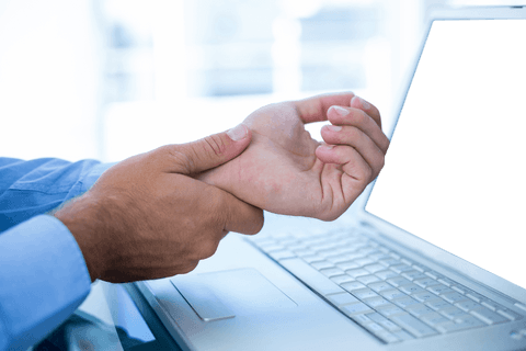 Businessman experiencing wrist pain by transparent laptop screen