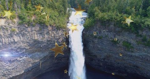 Plunging waterfall cascading into deep forest gorge with gold star overlay, aerial vista