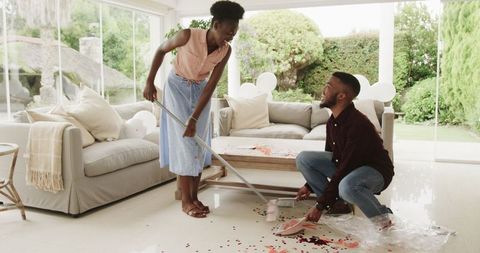 Young couple cleaning confetti after party celebration
