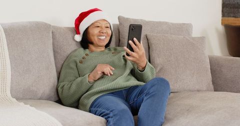 Senior Woman Enjoying Holiday Video Call with Santa Hat