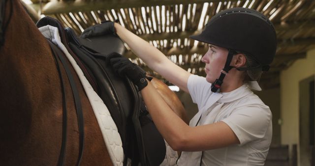 Female Equestrian Adjusting Saddle on Horse Before Riding - Download Free Stock Images Pikwizard.com