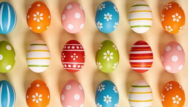 Colorful Patterned Easter Eggs in Symmetrical 4x5 Grid on Light Beige Tabletop