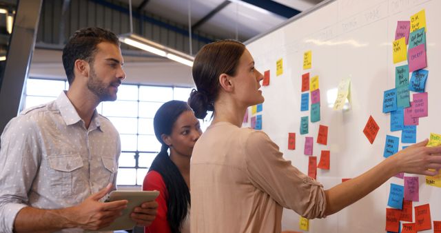 Diverse Team Collaborating on Whiteboard with Sticky Notes in Modern Office - Download Free Stock Images Pikwizard.com