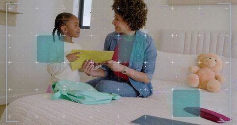 Parent and child sharing yellow envelope on bed, packing backpack and morning conversation