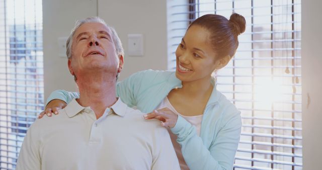 Young Caregiver Assisting Senior Man with Shoulder Pain - Download Free Stock Images Pikwizard.com