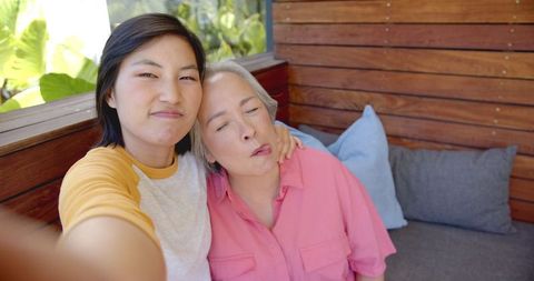 Happy Asian Family Enjoying Quality Time Taking Selfie on Patio Couch