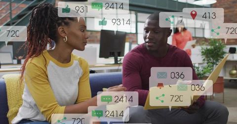 Young professionals collaborating with social media notifications and analytics on laptop